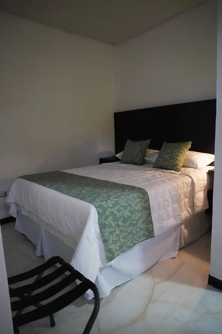 Habitación con cama doble y camino de mesa verde, Hotel Makao