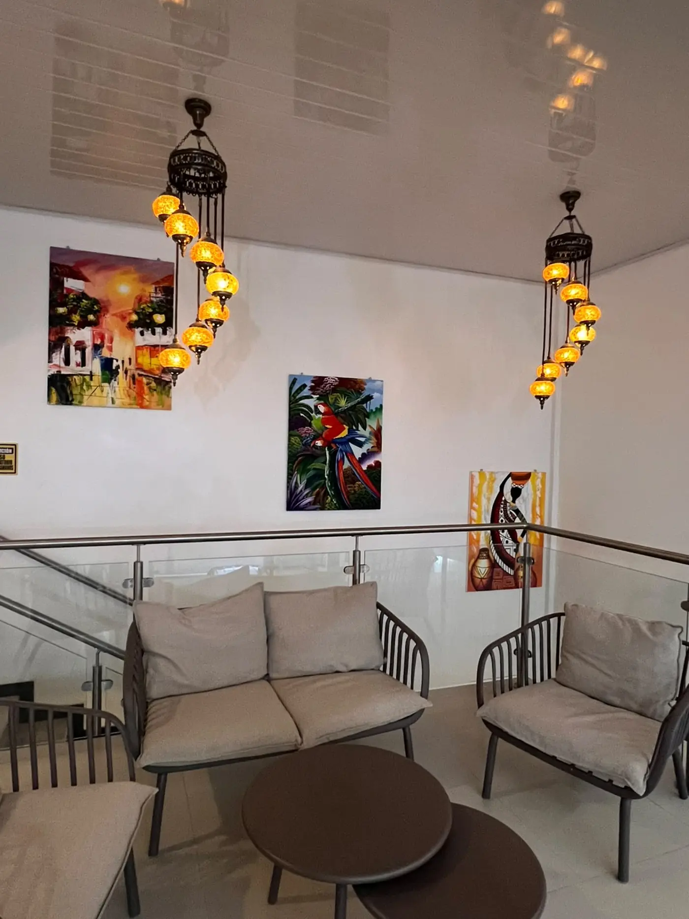 Rincón de lectura con arte local y lámparas colgantes, Hotel Makao